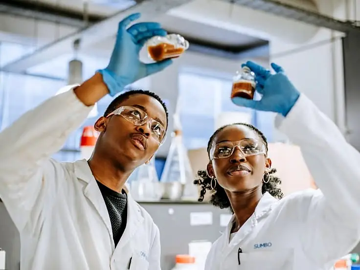 Two engineering students examining sample vials in a laboratory.