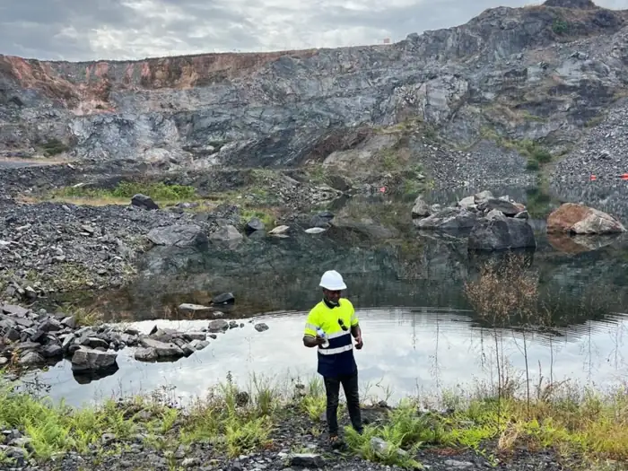 TSG engineer sampling water at a flooded open pit mine